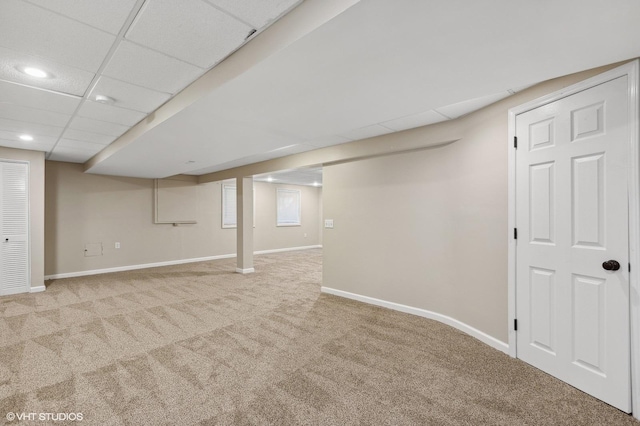 basement with light colored carpet and a drop ceiling