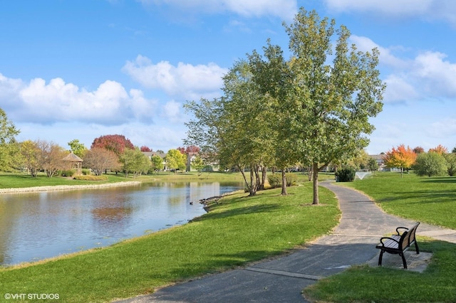 surrounding community featuring a water view and a lawn