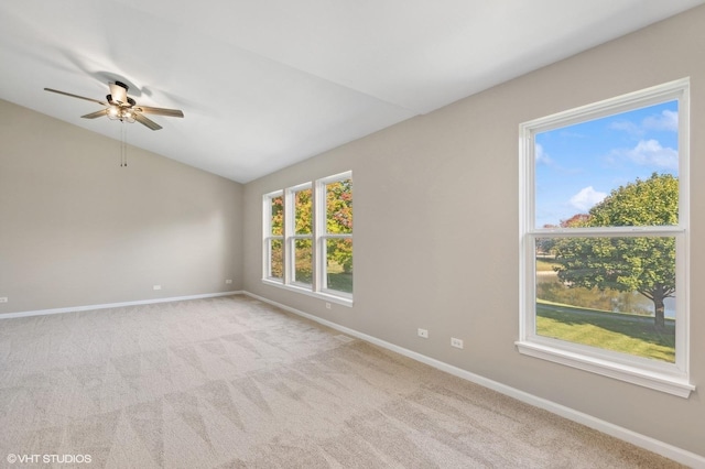 carpeted spare room with ceiling fan and vaulted ceiling