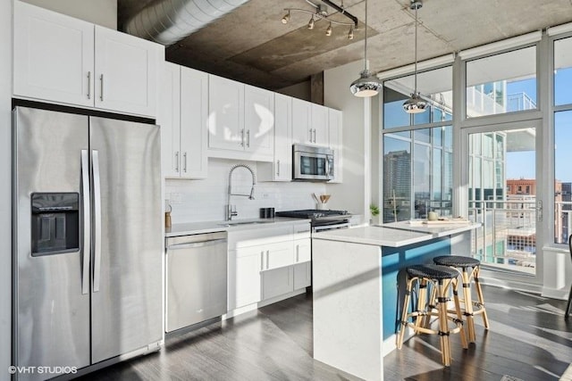 kitchen featuring pendant lighting, sink, appliances with stainless steel finishes, white cabinetry, and backsplash