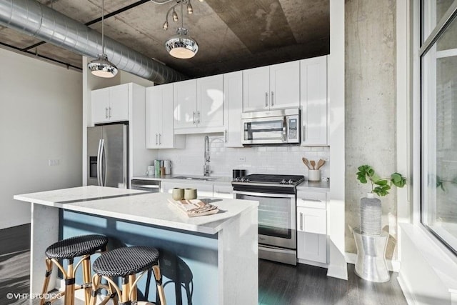 kitchen featuring sink, decorative backsplash, stainless steel appliances, and white cabinets