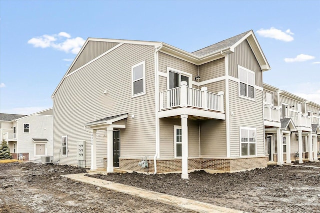 view of property exterior featuring a balcony and central AC unit