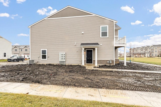 rear view of property featuring a balcony and central air condition unit