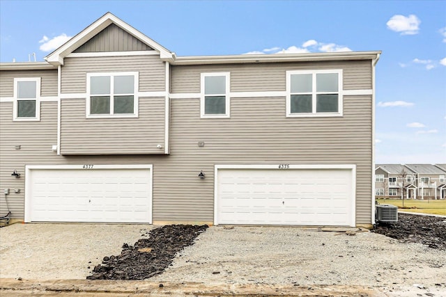 exterior space with central air condition unit and a garage