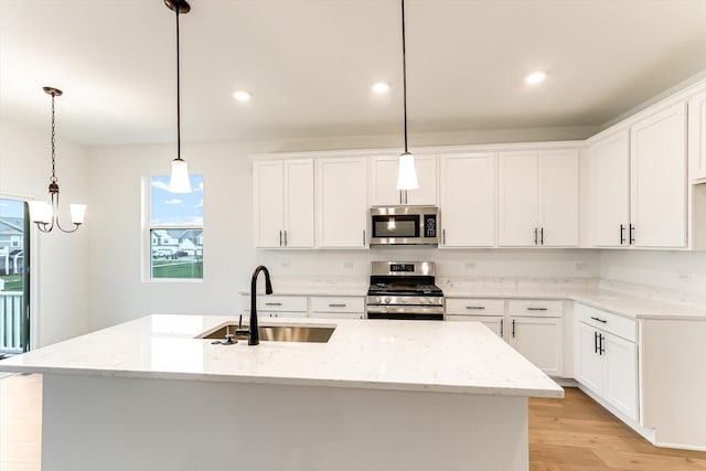 kitchen featuring sink, an island with sink, hanging light fixtures, and appliances with stainless steel finishes