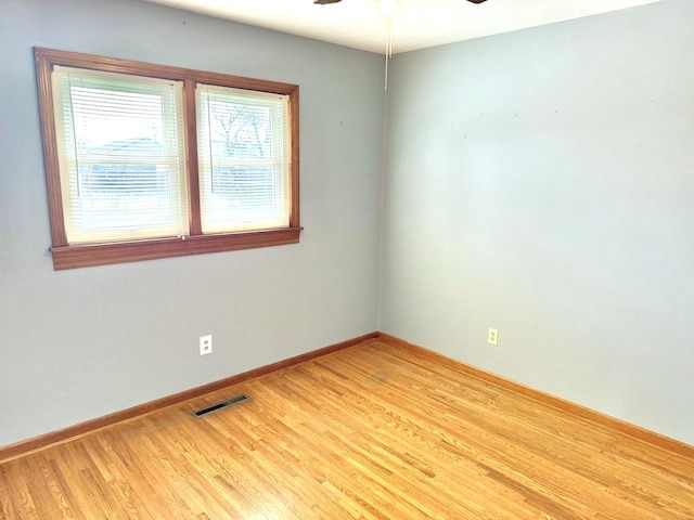 empty room with ceiling fan and light hardwood / wood-style floors