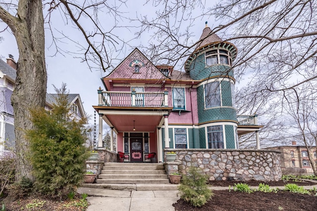 victorian home featuring a porch and a balcony