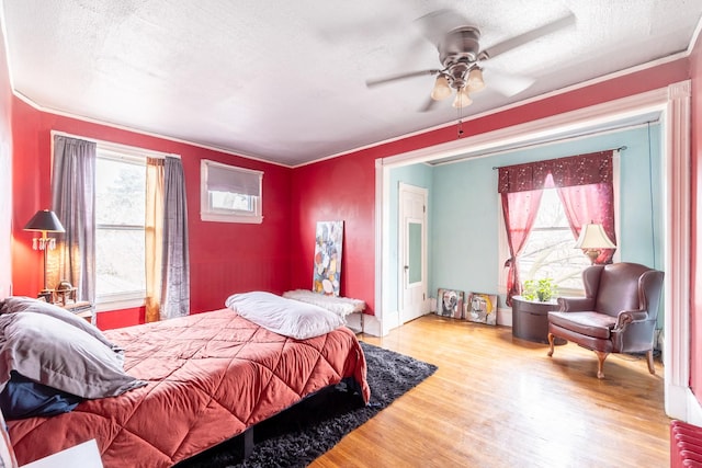 bedroom featuring wood finished floors, a textured ceiling, and ceiling fan