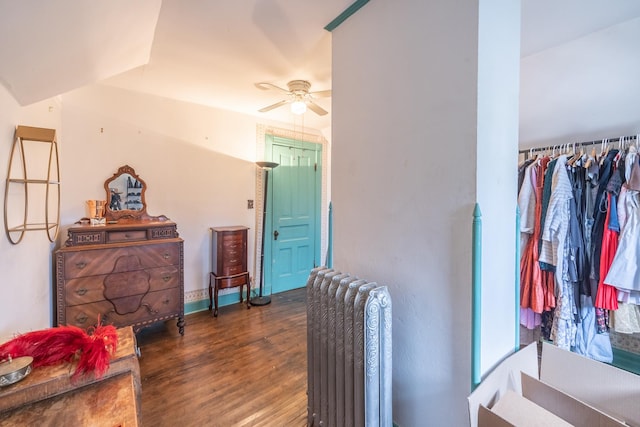 bedroom with ceiling fan, radiator heating unit, and wood finished floors
