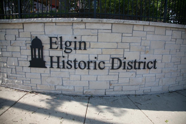 community / neighborhood sign featuring fence