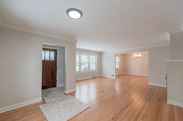 entrance foyer featuring light wood-type flooring, an inviting chandelier, and crown molding