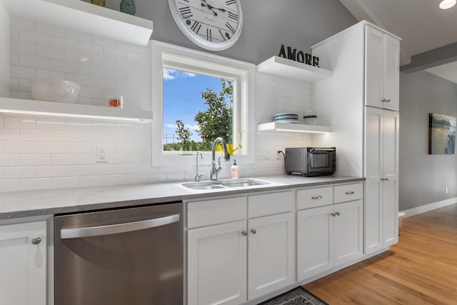 kitchen with white cabinets, tasteful backsplash, sink, dishwasher, and light hardwood / wood-style floors