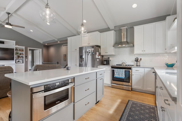 kitchen with white cabinetry, wall chimney exhaust hood, stainless steel appliances, backsplash, and pendant lighting