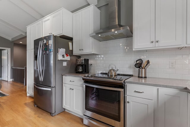 kitchen with white cabinets, wall chimney exhaust hood, and appliances with stainless steel finishes