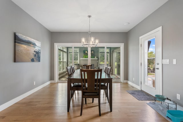 dining room with a wealth of natural light, light hardwood / wood-style flooring, and a chandelier