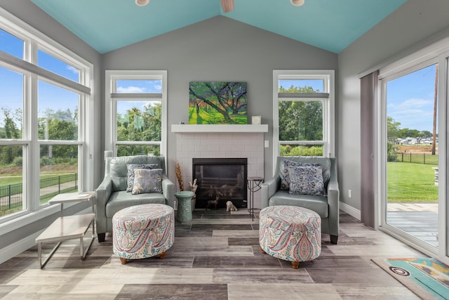 sunroom / solarium featuring a fireplace and vaulted ceiling