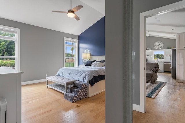 bedroom featuring stainless steel fridge, ceiling fan, light hardwood / wood-style floors, and lofted ceiling