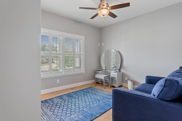 living area with hardwood / wood-style floors and ceiling fan