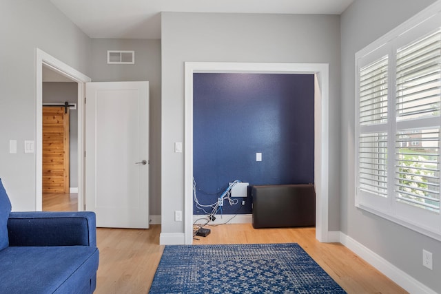 office area with hardwood / wood-style floors and a barn door