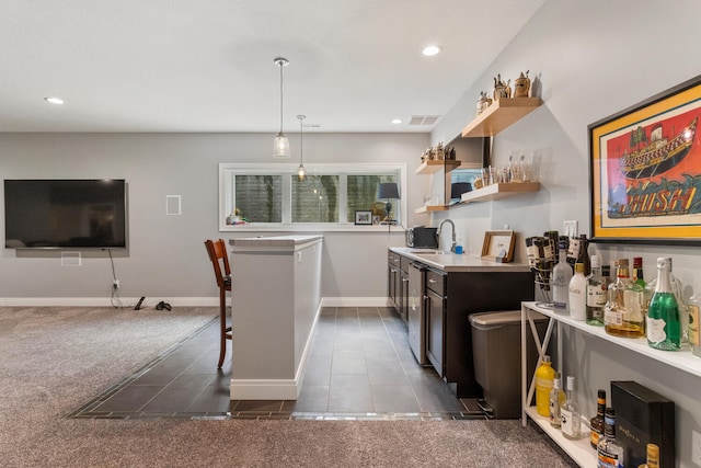 kitchen with a breakfast bar, dark carpet, sink, and hanging light fixtures