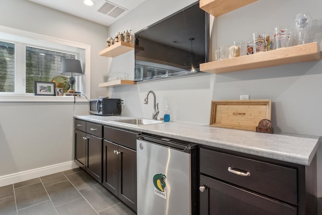 kitchen with stainless steel appliances, dark tile patterned flooring, and sink