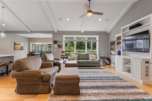 living room featuring ceiling fan with notable chandelier, lofted ceiling with beams, light hardwood / wood-style flooring, and a wealth of natural light