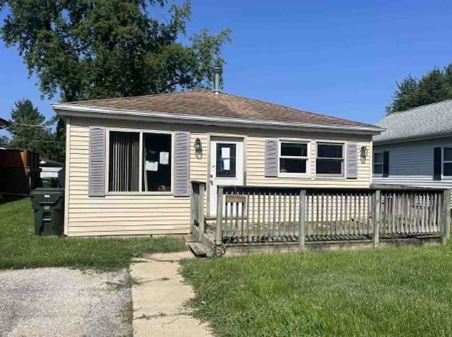 view of front of house with a deck and a front lawn