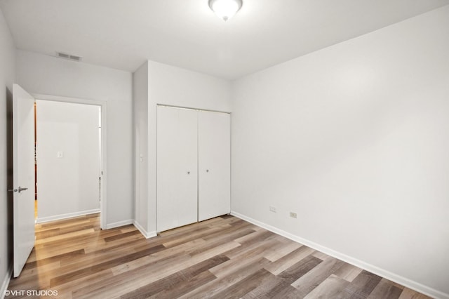 unfurnished bedroom featuring a closet and light wood-type flooring