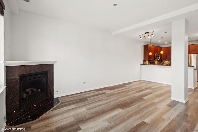 unfurnished living room with light hardwood / wood-style floors and a premium fireplace