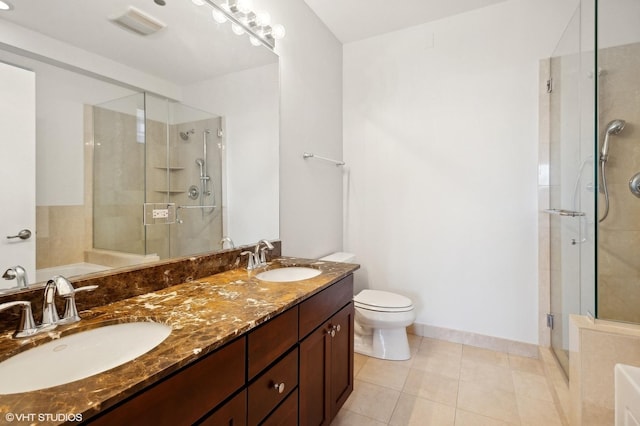 bathroom with tile patterned floors, toilet, vanity, and walk in shower