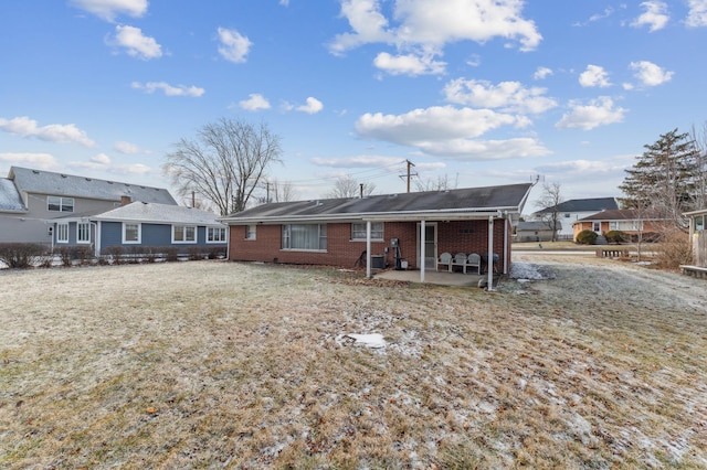 rear view of property featuring a lawn and a patio area