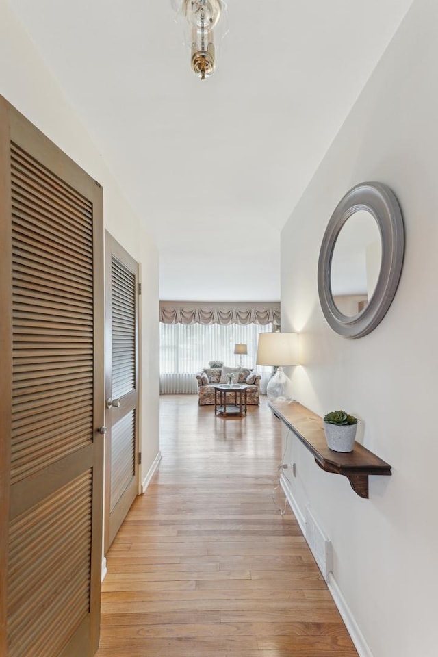 hallway with light hardwood / wood-style floors