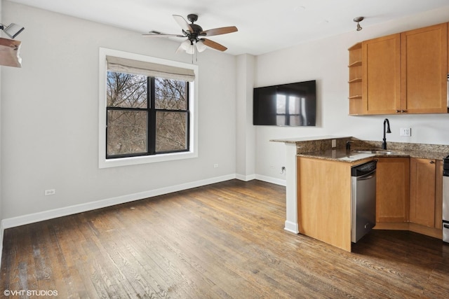 kitchen with dark hardwood / wood-style floors, dishwasher, sink, dark stone countertops, and ceiling fan