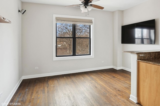 unfurnished living room with ceiling fan and dark hardwood / wood-style flooring