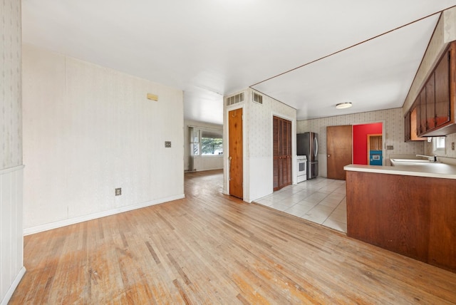 kitchen with sink, stainless steel fridge, and light hardwood / wood-style floors