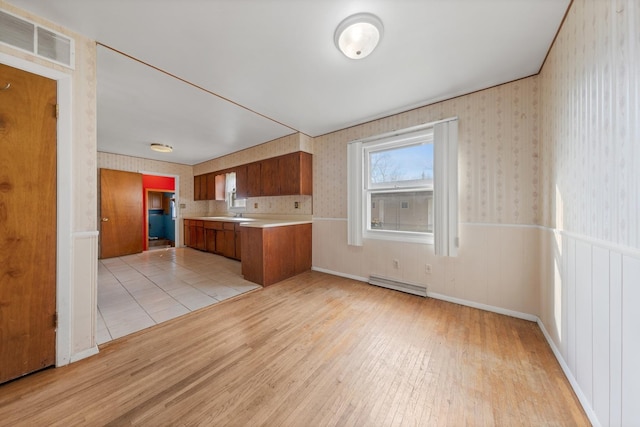 kitchen featuring baseboard heating and light hardwood / wood-style flooring