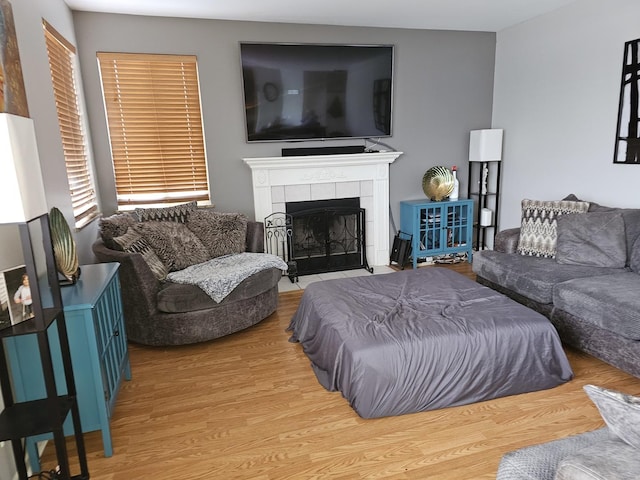 living room featuring hardwood / wood-style flooring and a tiled fireplace