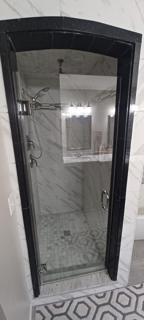 bathroom with a shower with door