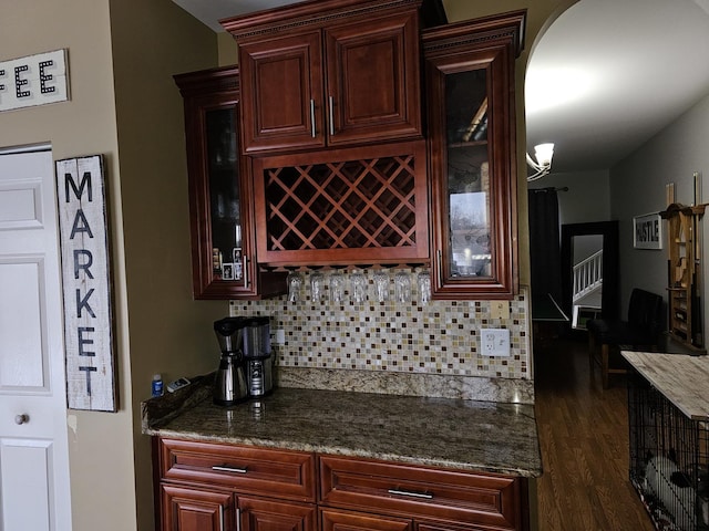 kitchen with stone countertops, dark wood-type flooring, and decorative backsplash