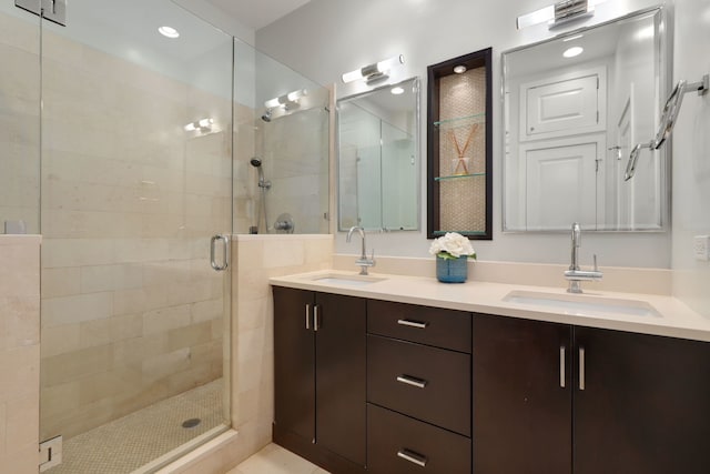 bathroom featuring a shower with shower door and vanity