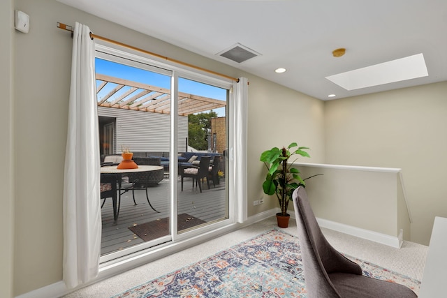 carpeted office space featuring a skylight