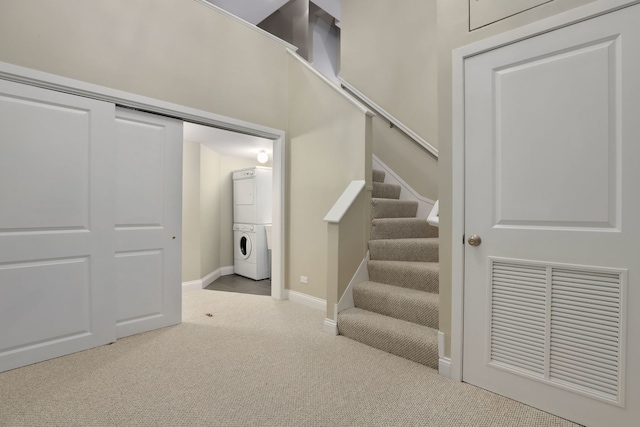 stairway featuring stacked washer / drying machine and carpet floors