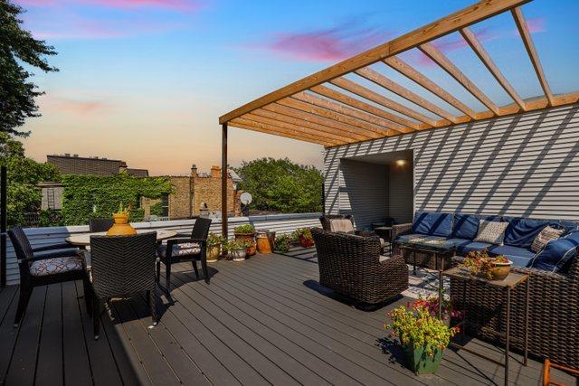 deck at dusk with a pergola and outdoor lounge area