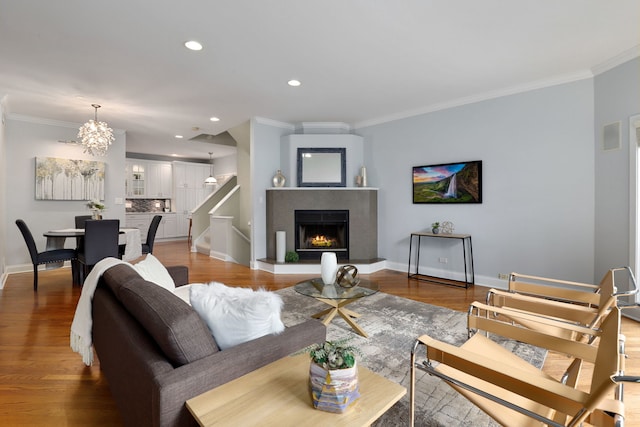 living room featuring a notable chandelier, ornamental molding, and hardwood / wood-style floors