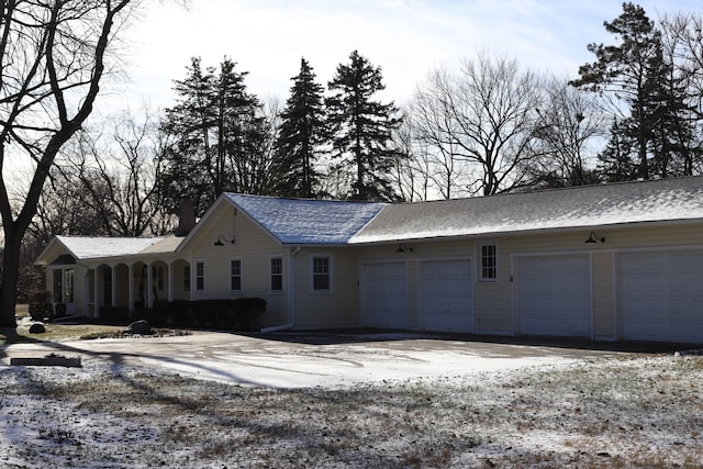 view of snowy exterior featuring a garage