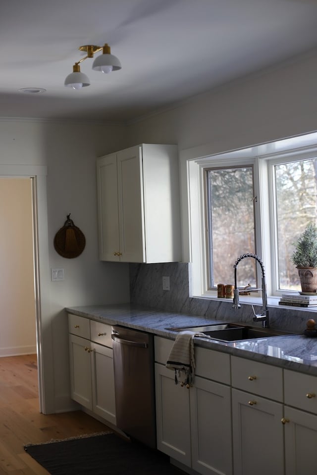 kitchen featuring dishwasher, light wood-type flooring, white cabinets, and sink