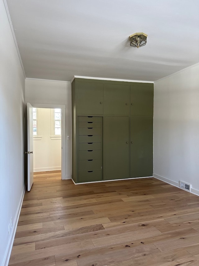 interior space with light hardwood / wood-style floors and crown molding