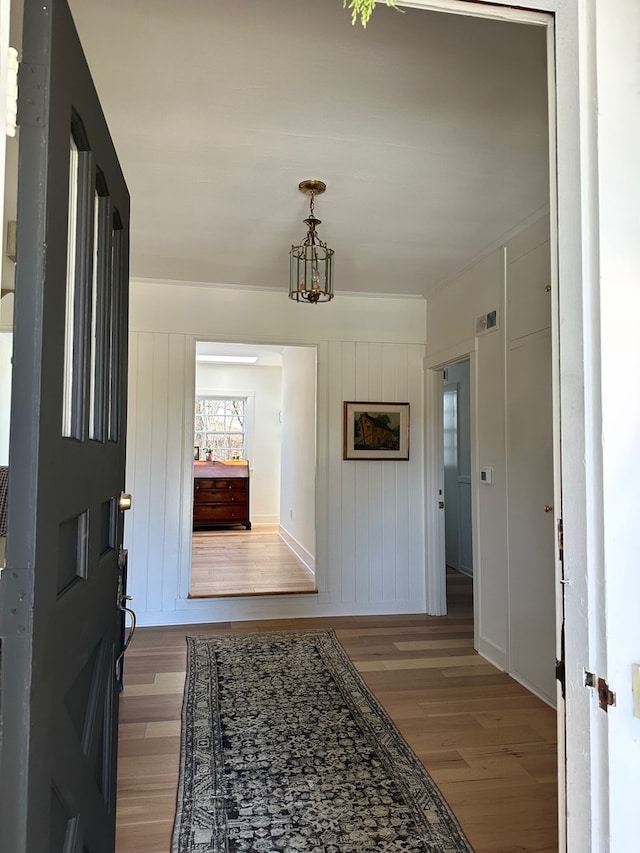 hallway with a chandelier and hardwood / wood-style flooring