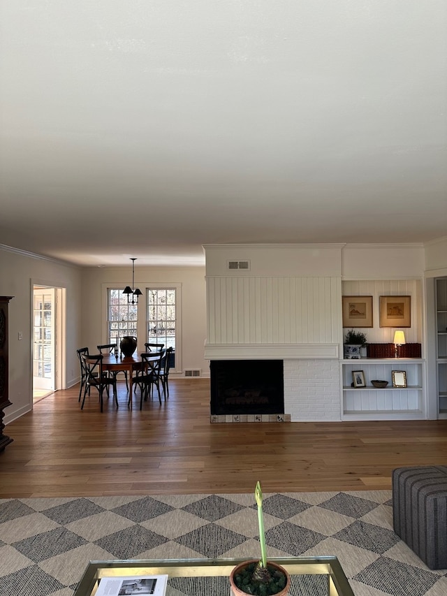 living room featuring a fireplace, dark hardwood / wood-style flooring, and crown molding