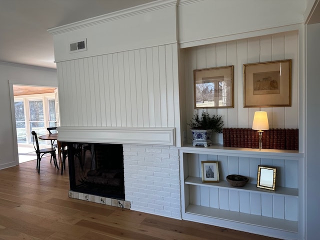 details featuring crown molding, a fireplace, and hardwood / wood-style floors